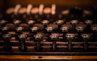 An antique typewriter with a worn wooden casing, missing its keys.