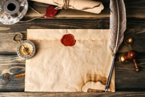 Quill pen and old paper sheet on wooden background top view